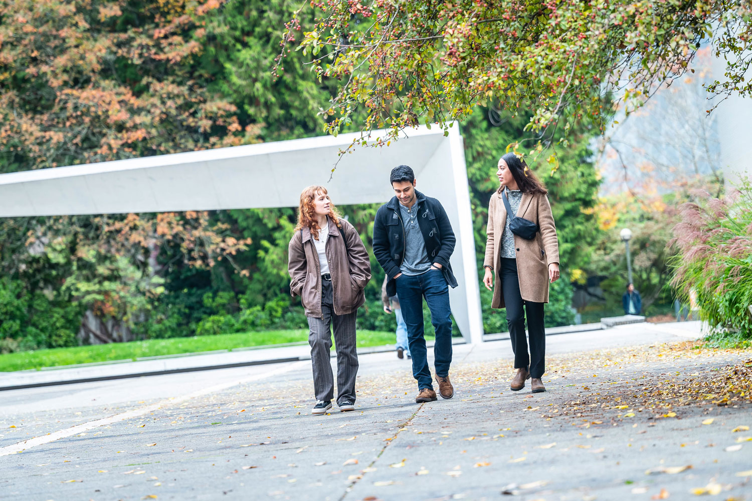 A group of three people walking in the Buchanan courtyard at the UBC Vancouver campus